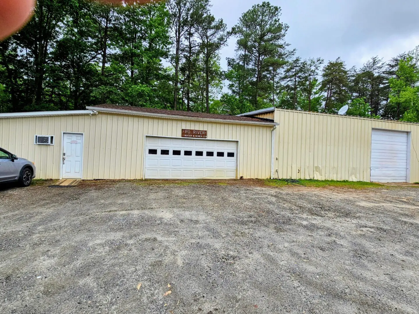 A large garage with two doors and trees in the background.