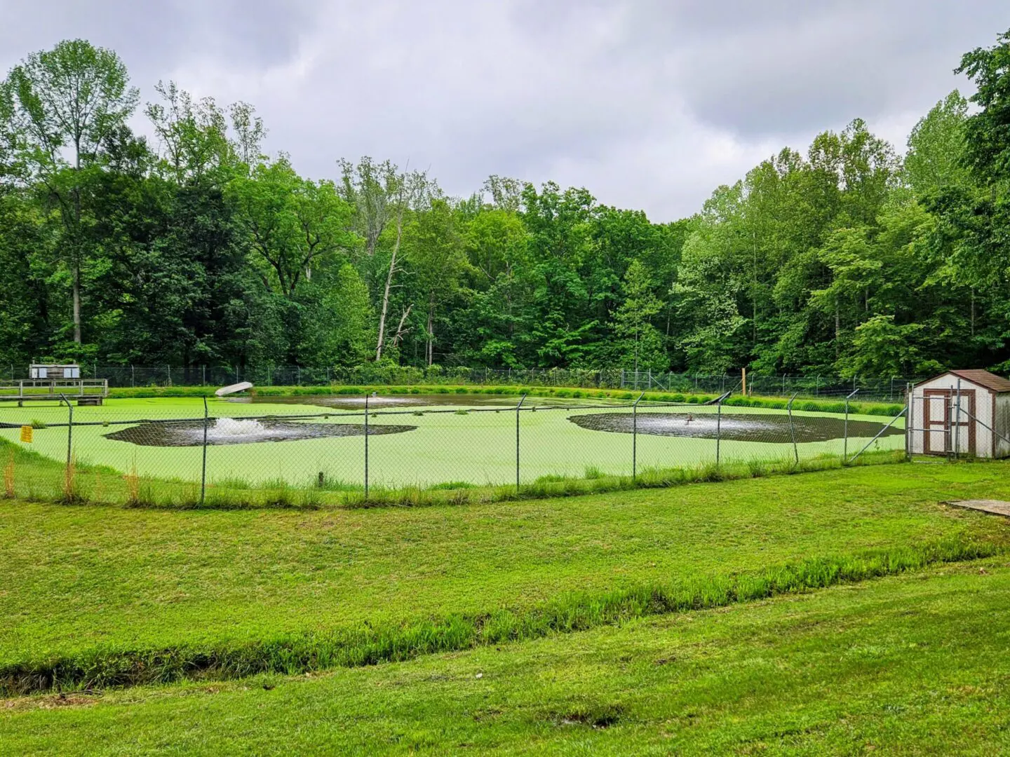 A tennis court in the middle of a field.